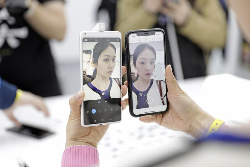 An attendee holds the Xiaomi Corp. Mi MIX 2S smartphone, left, side-by-side with an Apple Inc. iPhone X while testing their front-facing cameras at an unveiling event in Shanghai, China, on Tuesday, March 27, 2018. Xiaomi unveiled its latest top-tier smartphone to bring the fight to Apple and Samsung, as the Chinese startup readies a highly anticipated initial public offering. Photographer: Qilai Shen/Bloomberg