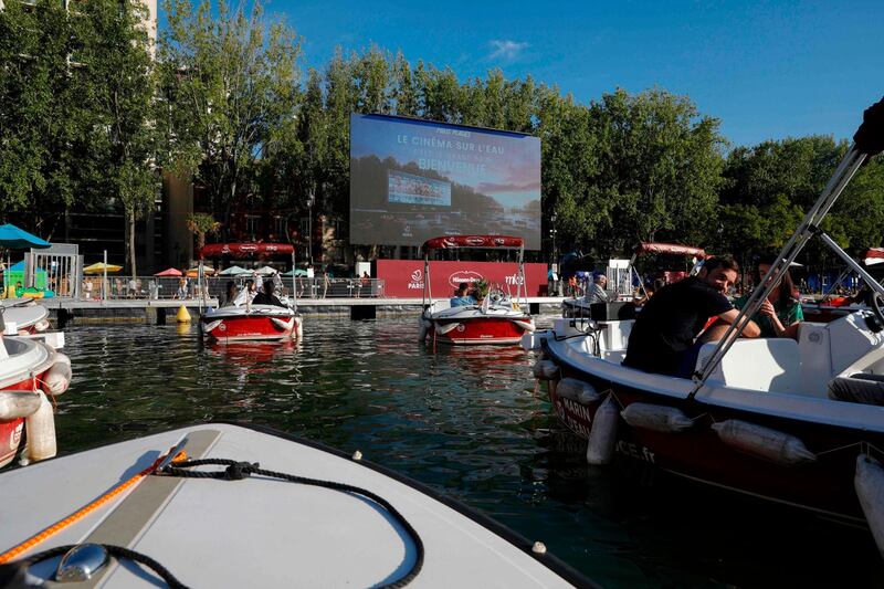 People attend the screening of the French movie 'Le grand bain' on the first day of the 19th year of the Paris Plages summer event. AFP