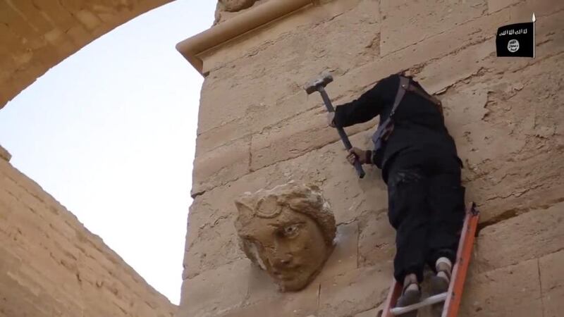 In an image from an ISIL video posted on YouTube in 2015, a militant hammers away at a face on a wall in Hatra, a large fortified city recognised as a Unesco World Heritage site, south-west of Mosul in Iraq. AP Photo / Militant video