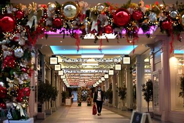 A shopper wearing a face mask due to the pandemic walks through the Christmas-decorated Royal Exchange shopping arcade in the centre of Manchester, northwest England. AFP