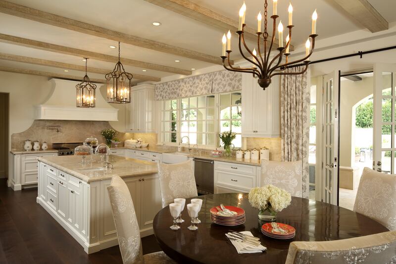 An open-plan chef's kitchen features a marble-topped island and a table for six. Photo: Sotheby’s International Realty