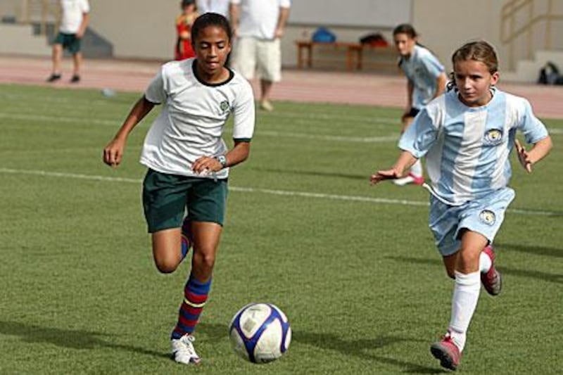 Girls from the Al Yasmina School, left, and the British School al Khubairat play in a football tournament played at Al Yasmina School in Abu Dhabi this week. Five girls' teams took part in the competition.
