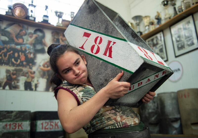 Basque 'Harrijasotzaile' stone lifter Udane Ostolaza, 15, carries a large boulder during a training session in the Spanish Basque city of Orio. AFP