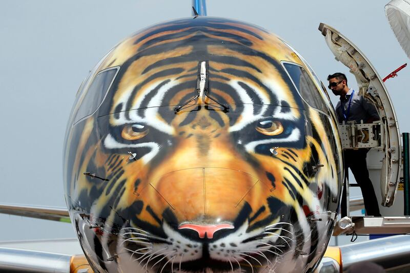 A man enters the cabin of an Embraer E190-E2 commercial jet with a tiger design painted on its nose at the static display ahead of the Singapore Airshow at the Changi Exhibition Centre in Singapore. Wallace Woon / EPA