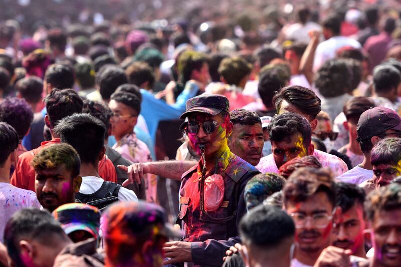 Police officers smeared with coloured powder walk in the crowd as revellers celebrate Holi in Kathmandu, Nepal. AFP