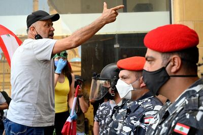 epa08429682 An anti-government protester faces off riot police during a protest in front of the Ministry of Economy in downtown Beirut, Lebanon, 18 May 2020. The ecountry is currently goning through the worst financial crisis in history as the Lebanese Lira has slumped since October, hiking prices, fuelling unrest and locking depositors out of their US dollar savings.  EPA/WAEL HAMZEH