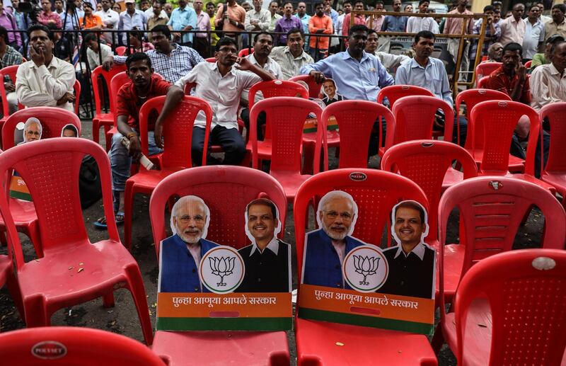 epa07945303 Placards showing Indian Prime Minister Narendra Modi and Maharashtra Chief Miinster Devendra Fadnavis placed on chairs during celebration of Bharatiya Janta Party (BJP) lead in the Maharashtra state elections outside BJP head office in Mumbai, India, 24 October 2019. Party supporters and media gathered outside the BJP headquarters to know the results of the legislative elections held on 21 October 2019.  EPA/DIVYAKANT SOLANKI
