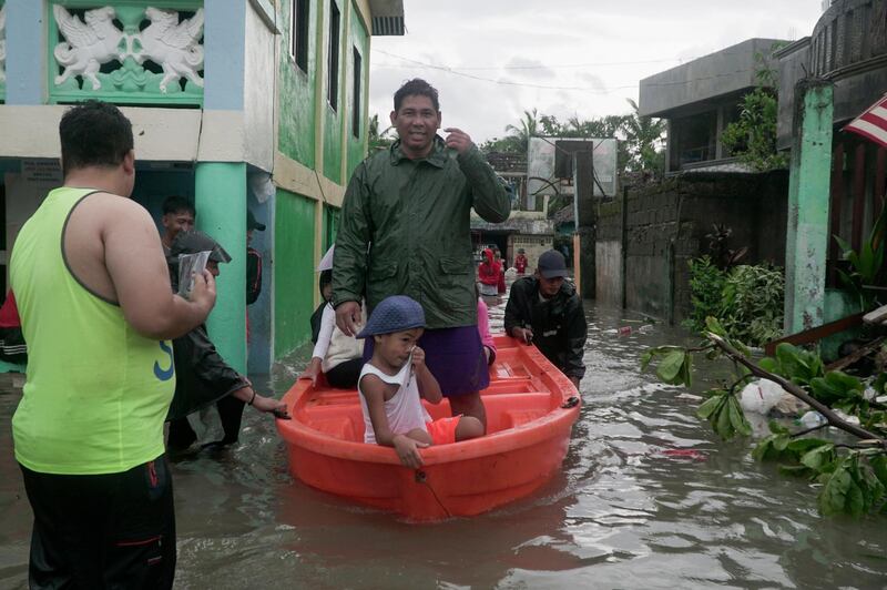 Residents ride a boat along a flooded village as Typhoon Vongfong passes by Sorsogon province, Philippines. AP