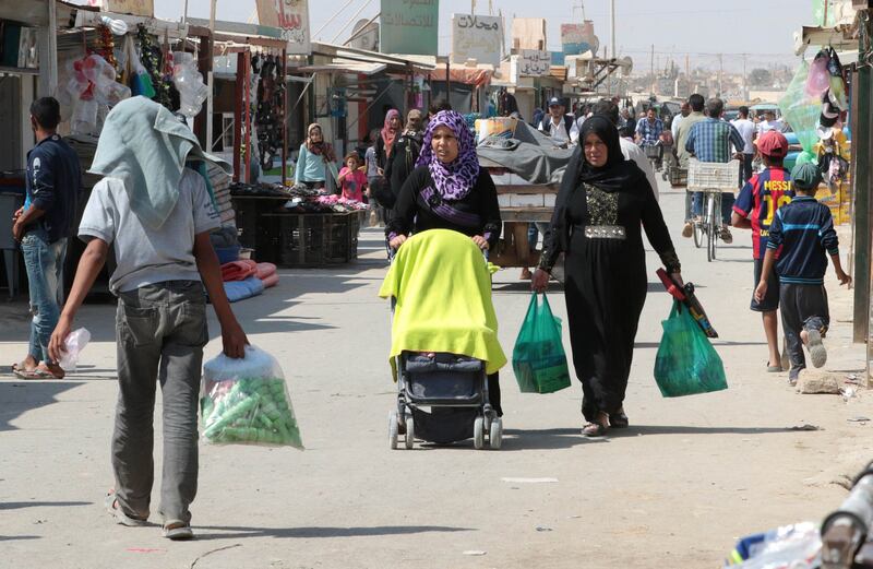 Syrian refugees walk along a road in the Zaatari refugee camp, north-west Jordan. AFP