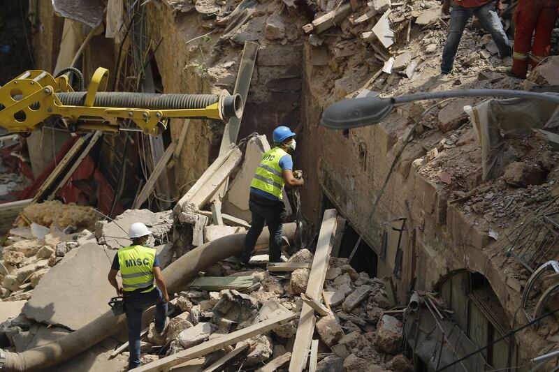 Rescue workers prepare to use a tube to vacuum debris from a badly damaged building in Lebanon's capital Beirut, in search of possible survivors from a mega-blast at the adjacent port one month ago, after scanners detected a pulse. Lebanese rescuers scoured rubble for a possible survivor in Beirut after the detection of a pulse drew crowds hopeful of a miracle one month on from a devastating explosion.  AFP