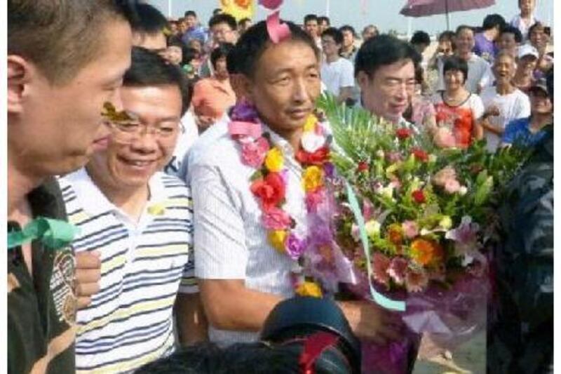 Zhan Qixiong, the Chinese trawler captain, with flowers, returns to his hometown in Jinjiang city on Monday. Reuters