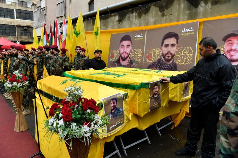 Hezbollah members stand next to coffins during a funeral in a southern suburb of Beirut, Lebanon. EPA