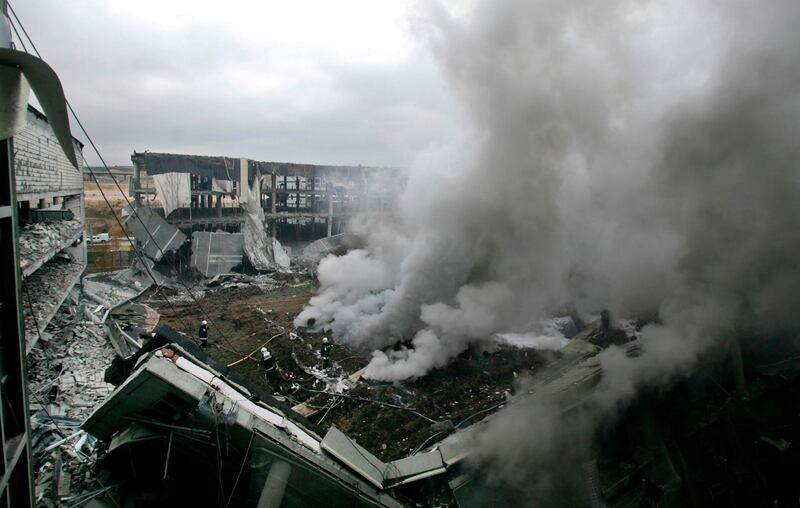 FILE - In this Dec. 30, 2006 file photo, plumes of smoke rise as firefighters work at the scene after a car bomb exploded in a parking lot at Madrid's new airport terminal. The Basque militant group ETA says it has "completely dissolved all its structures" after a 60-year armed independence campaign, but the Spanish government vowed Wednesday, May 2, 2018 not to abandon the investigation of crimes from the group's violent past. (AP Photo/Bernat Armangue, File)