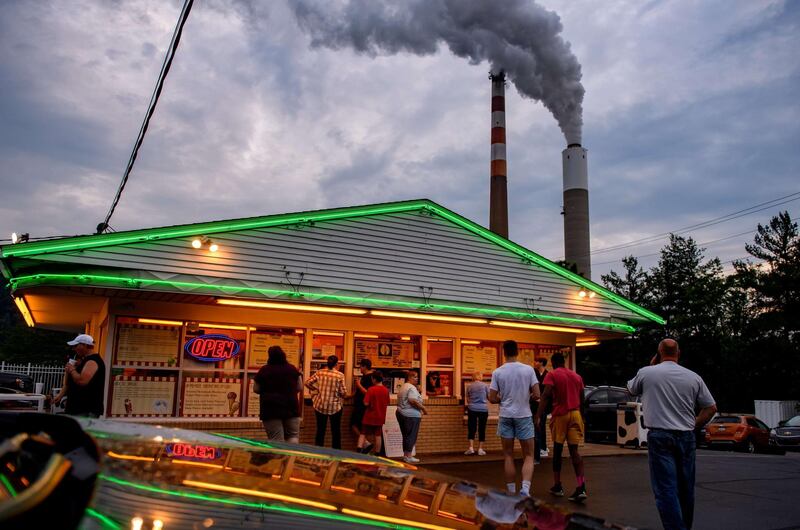 CHESWICK, PA - JUNE 07: People line up for ice cream at Glens Custard in the shadow of GenOns Cheswick Power Station, which still burns coal to produce 637 megawatts of electricity for the region on June 7, 2021 about 15 miles northeast of Pittsburgh in Cheswick, Pennsylvania. Scientists from Scripps Institution of Oceanography and the National Oceanic and Atmospheric Administration reported today that despite a year-long pause in much of the economy due to the Covid-19 pandemic, levels of atmospheric carbon dioxide reached the highest levels since accurate measurements began 63 years ago, according to published reports.   Jeff Swensen/Getty Images/AFP
== FOR NEWSPAPERS, INTERNET, TELCOS & TELEVISION USE ONLY ==
