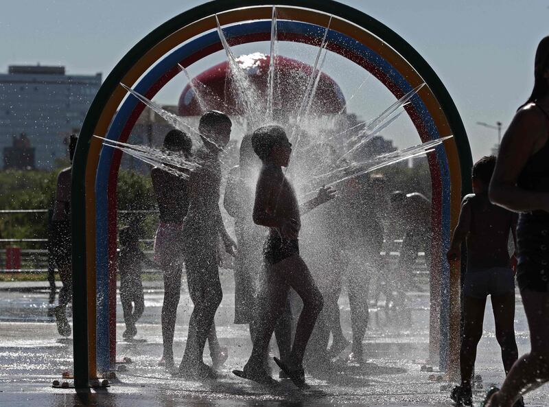 Children cool off in a water game at the Parque de los Ninos (Children's Park), in Buenos Aires, Argentina. AFP