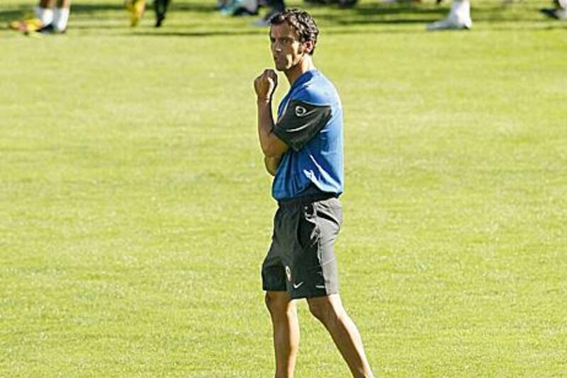 epa01910710 Atletico Madrid's new coach Spanish Quique Sanchez Flores oberserves his players during a training session at the Vicente Calderon stadium in Madrid, Spain, 26 October 2009, ahead to their Copa del Rey Cup match against Marbella on 27 October. The former coach of Getafe, Valencia and Benfica was presented today after signing a deal to the end of the season with Atletico after Abel Resino was sacked from the team owing to a poor start in La Liga.  EPA/BALLESTEROS