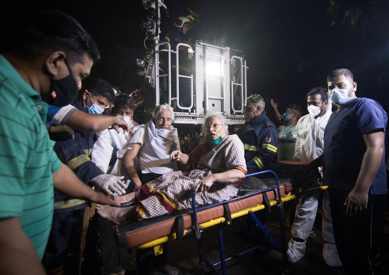 People carry a woman on a stretcher towards a safer place after a fire broke out at a coronavirus hospital in Mumbai, India. Reuters