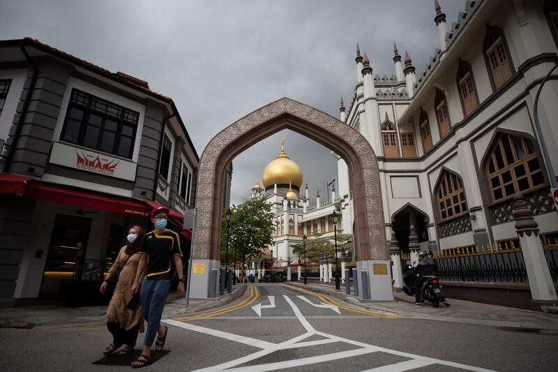 A Muslim couple wearing protective face masks walk past the closed Sultan Mosque, at Kampong Glam District in Singapore, on April 24, 2020. EPA