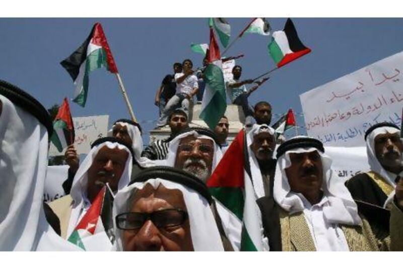 Palestinians wave the national flag during a rally to support the political unity deal between the Hamas movement, which rules in the Gaza Strip, and its West Bank rival party Fatah, in Gaza City yesterday.