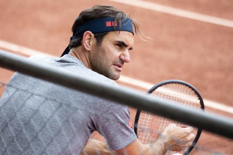 Roger Federer talks with his coach during training. EPA