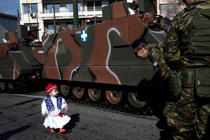 A boy walks in front of military vehicles during a parade marking Greece's Independence Day in Athens. EPA 