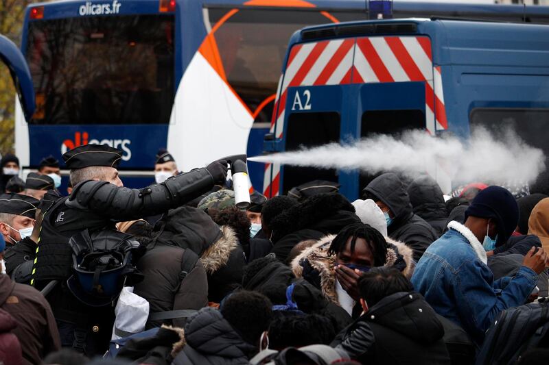 French police forces spray tear gas as they evacuate migrants from a makeshift migrant camp. EPA