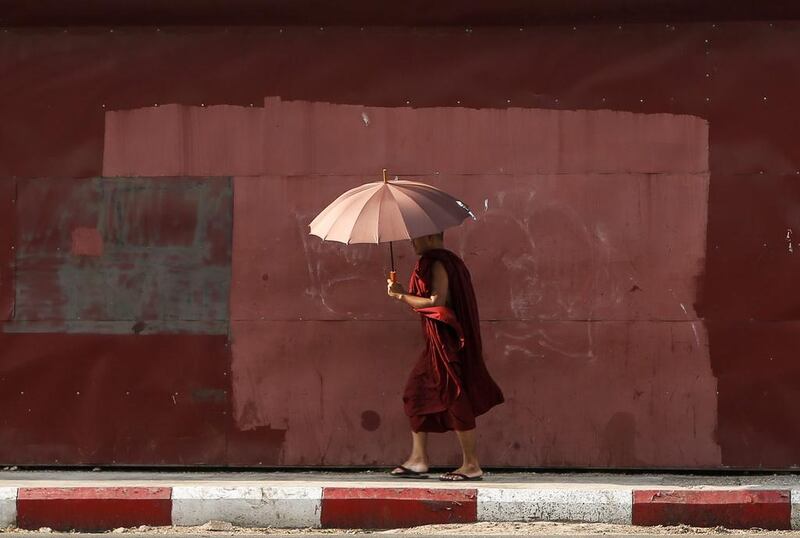 A Buddhist monk uses an umbrella to protect himself from the sun on a hot summer’s day in Yangon, Myanmar. Lynn Bo Bo / EPA