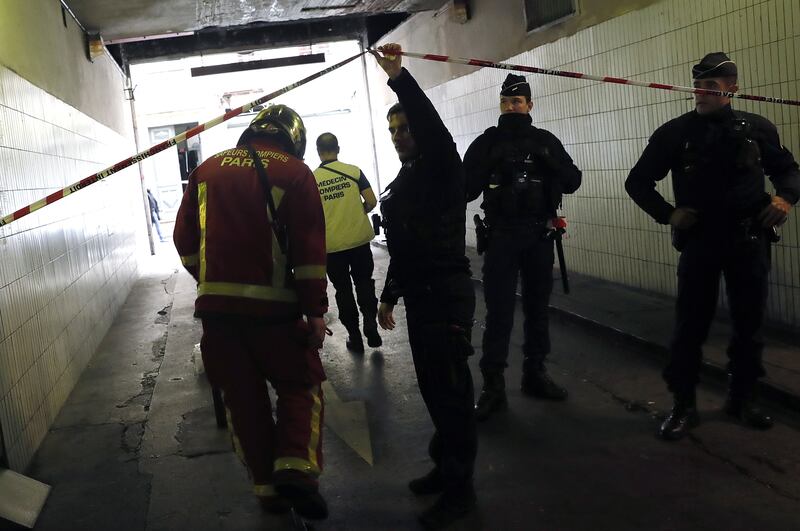 A police officer lets emergency services workers through a cordon securing the area. EPA