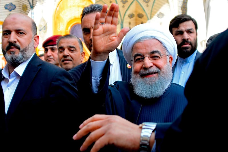 Iranian President Hassan Rouhani (C) visits in the Iraqi central city of Najaf on March 13, 2019. Iran's President Hassan Rouhani hit back on March 11 against pressure from the "aggressor" United States on Iraq to limit ties with its neighbour, during his first official visit to Baghdad. Shiite-majority Iraq is walking a fine line to maintain good relations with its key partners Iran and the United States which themselves are arch-foes. / AFP / Haidar HAMDANI
