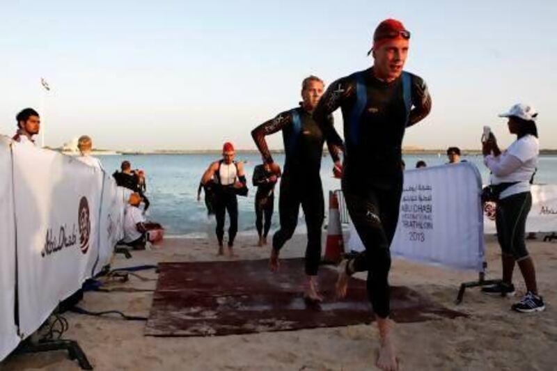 Elite long distance triathletes exit the water during the swim section. Christopher Pike / The National