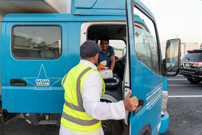 DUBAI, UNITED ARAB EMIRATES. 07 MAY 2019. Iftar meals being distributed to motorists by Marwan Al Hassan (wearing the baseball cap) and his team at the intersection of Al Asayel and 13D Str in Al Quoz 1. (Photo: Antonie Robertson/The National) Journalist: None. Section: National.