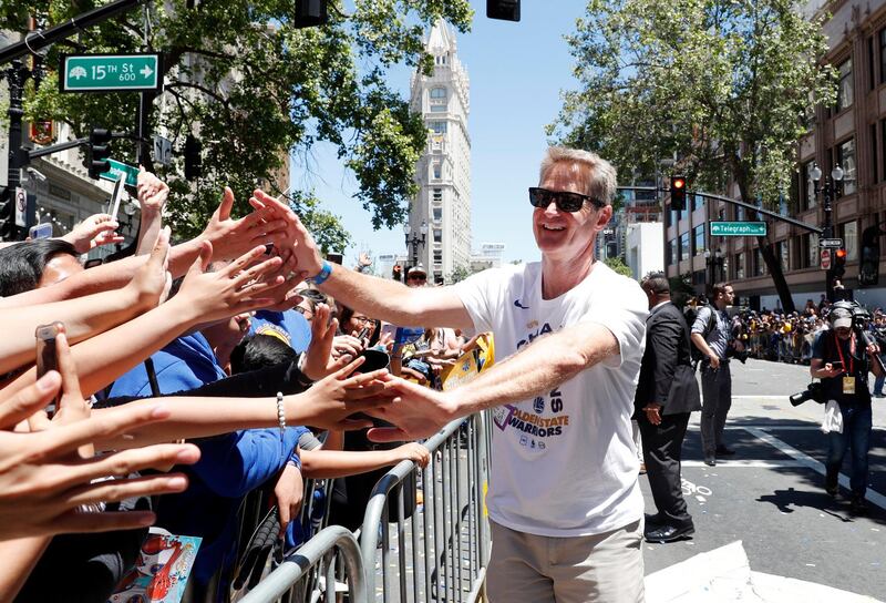 Golden State Warriors head coach Steve Kerr high-fives fans. Kerr has now won three NBA Championships in his four seasons with the team, after wining five championships as a player with the Chicago Bulls and San Antonio Spurs. Tony Avelar / AP Photo