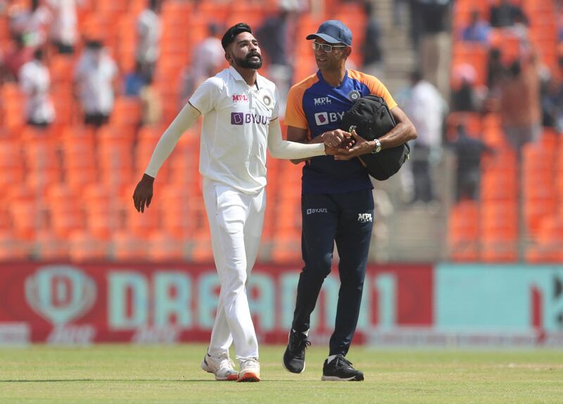 Team physiotherapist checks out India's Mohammed Siraj, left, after he got hurt while fielding on Saturday. AP