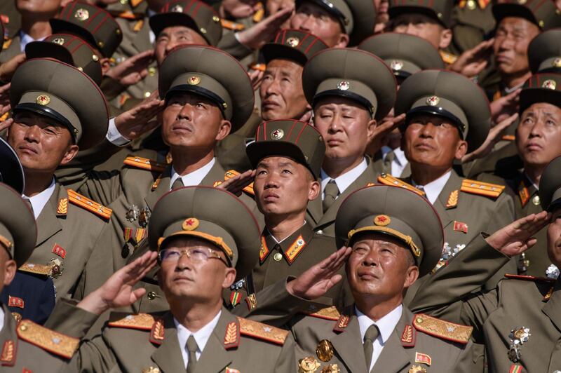 Korean People's Army (KPA) soldiers salute as they watch a mass rally on Kim Il Sung square in Pyongyang.  AFP