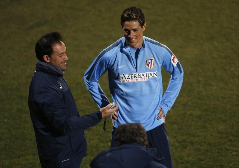 Fernando Torres talks with Atletico Madrid trainer Oscar Ortega, back to the camera, at Tuesday's team training session. Susana Vera / Reuters