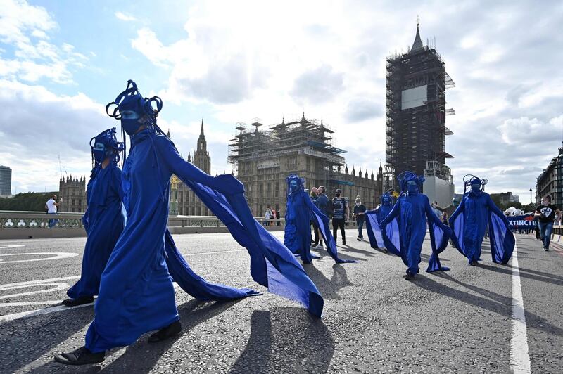 TOPSHOT - Activists from the climate change group Extinction Rebellion lead a procession across Westminster Bridge in central London on September 6, 2020 on the sixth day of their new series of 'mass rebellions'. Climate change protesters converged on the British parliament on September 1, kicking off 10 days of demonstrations to be held across the country by activist group Extinction Rebellion. / AFP / JUSTIN TALLIS
