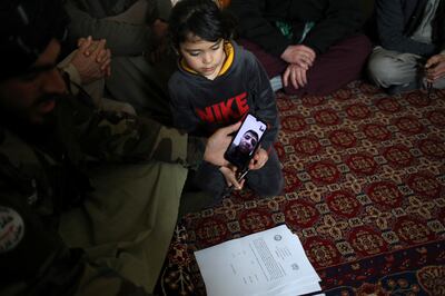 A Taliban member speaks to baby Sohail Ahmadi's father by video at the house of taxi driver Hamid Safi. Reuters