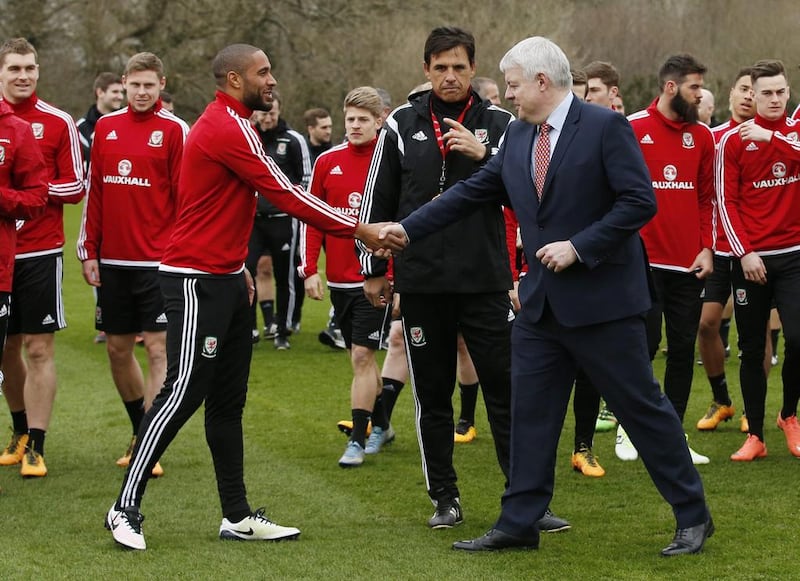 Wales’ Ashley Williams shakes hands with First Minister of Wales Carwyn Jones as manager Chris Coleman and team mates look on during training. Reuters / Andrew Boyers