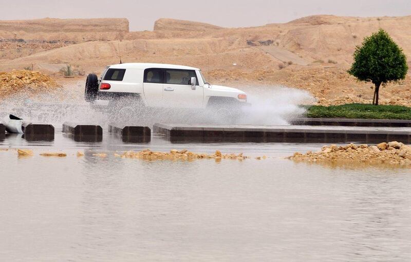 A car drives through a flooded street. Fayez Nureldine / AFP Photo