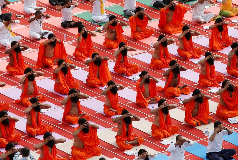 Participants dressed as Hindu holy men or sadhus perform yoga at a stadium during International Yoga Day in Ahmedabad, India. Reuters