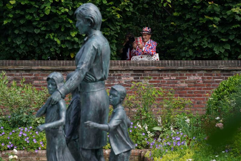 A man takes a photograph of the statue of Diana, Princess of Wales, a day after the artwork was unveiled in the Sunken Garden at Kensington Palace, London.