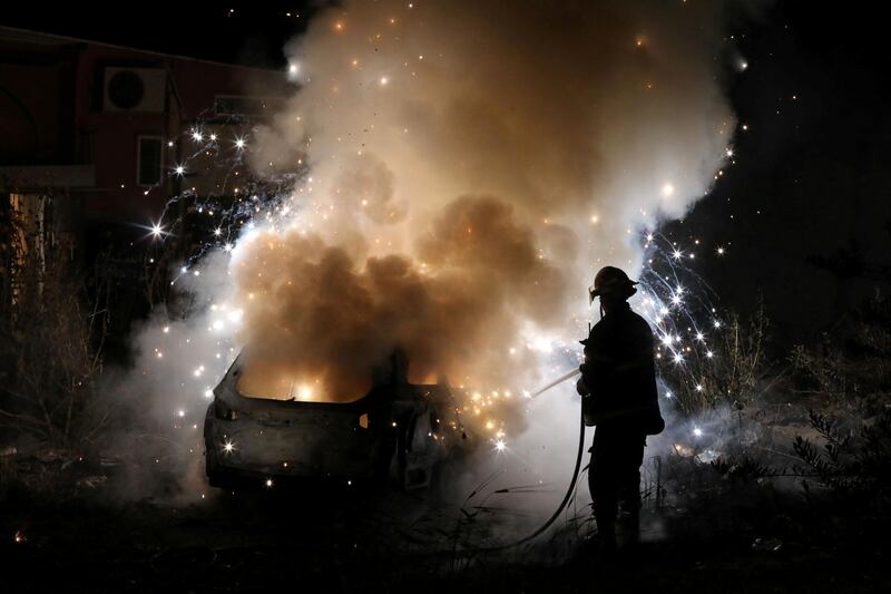 A firefighter tackles a burning car belonging to Jewish settlers in Sheikh Jarrah, East Jerusalem, on May 6, 2021. Tension is rising over a bid to evict Palestinian families from homes on land claimed by the settlers. Reuters
