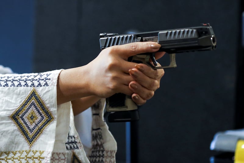 Mona Al Khurais takes aim with a pistol.