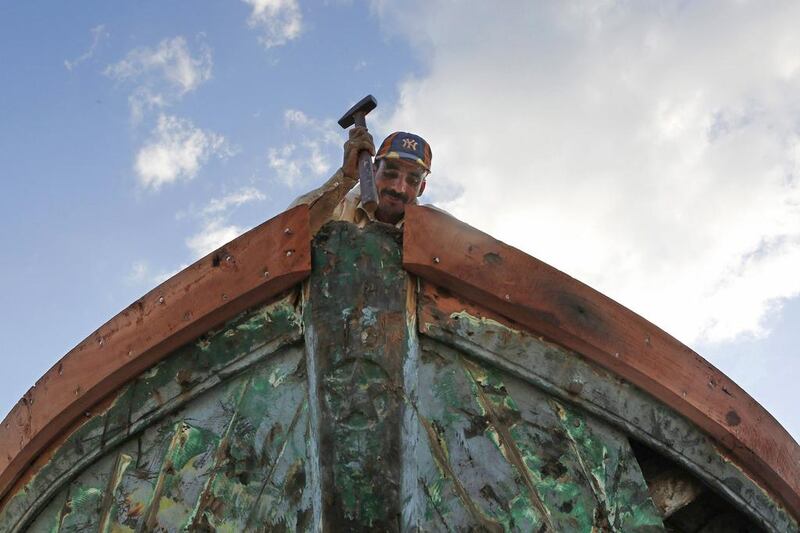 A fisherman repairs his boat at the entrance to the fishermen’s village of El Max. Amr Abdallah Dalsh / Reuters