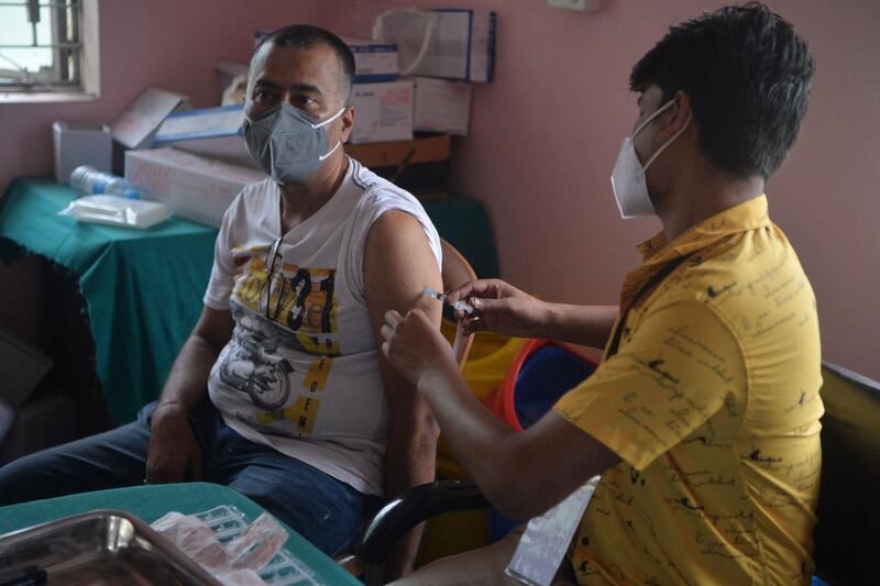 A healthcare worker inoculates a man working in the tourism industry with a dose of the Covishield vaccine against the Covid-19 coronavirus at a primary health centre in Siliguri on June 19, 2021. / AFP / Diptendu DUTTA
