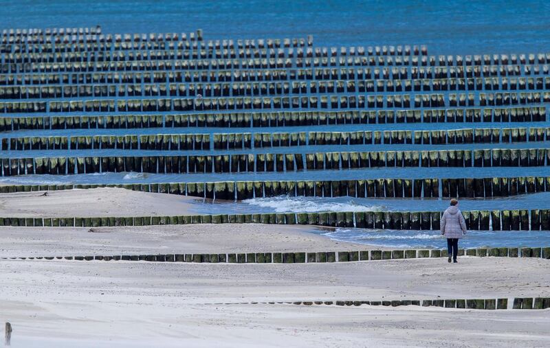 A lone walker is out and about on the otherwise deserted beach near the pie in Koserow, Germany. AP Photo