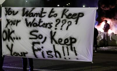 French fishermen hold a banner as they block lorries carrying UK-landed fish to protest for the slow issuance of licenses to fish inside British waters, at the fishing port in Boulogne-sur-Mer, France, April 23, 2021. REUTERS/Pascal Rossignol