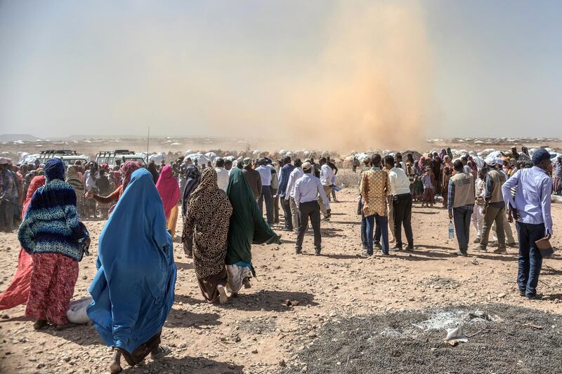 People gather prior to a food distribution at the Internally displaced person camp (IDP) of Farburo in Gode, near Kebri Dahar, southeastern Ethiopia, on January 27, 2018. - The camp recently hosted Somali families fleeing conflict between Somali and Oromo communities in Ethiopia. In Ethiopia’s Somali region there are 264 sites largely populated by drought-displaced families. (Photo by YONAS TADESSE / AFP)