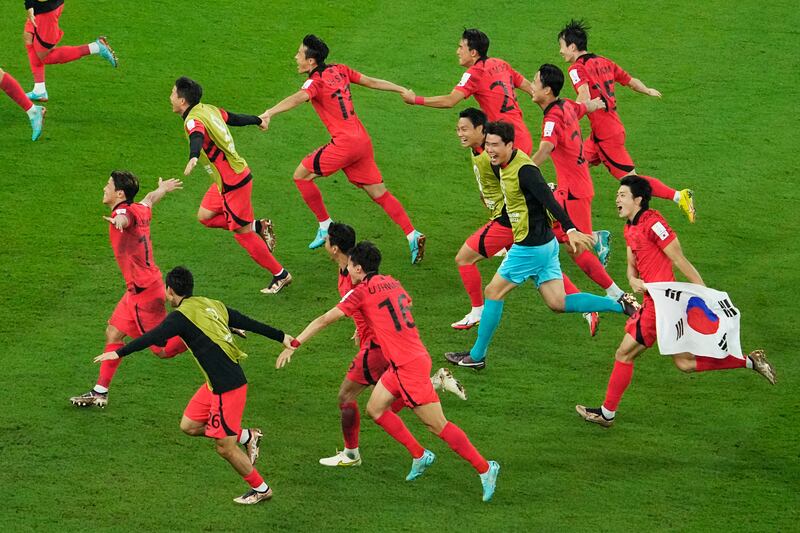 South Korea's players celebrate after finding out they had qualified for the last-16 ahead of Uruguay. AP
