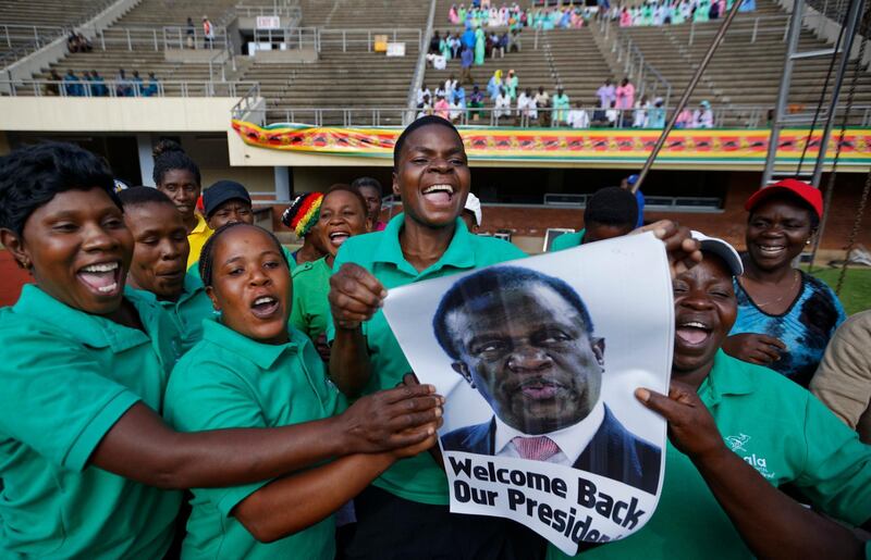Zimbabweans hold up a picture of Mnangagwa. Ben Curtis / AP Photo